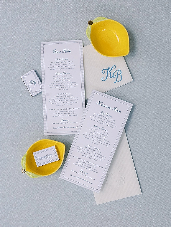 Wedding menu cards with wedding menu design, place cards and monogram stationery styled on a light blue linen tablecloth with lemon bowls