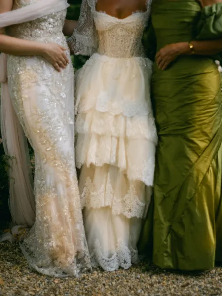 Bridesmaid dress colors in mismatched bridesmaid dresses, green and gold tones with satin and lace accents against outdoor greenery