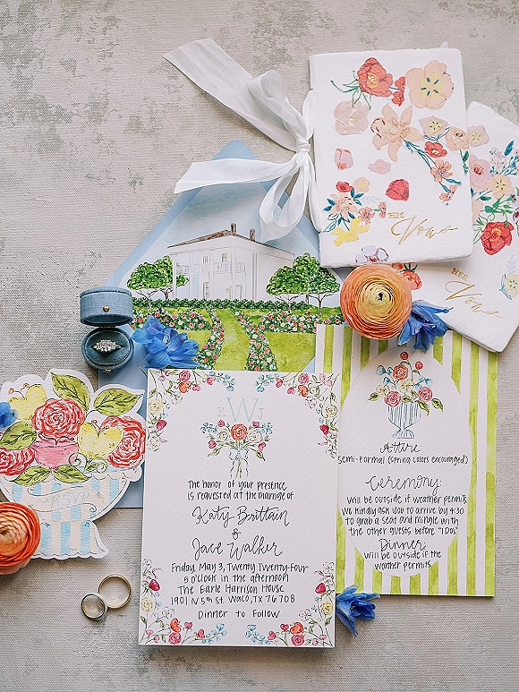 Invitation suite with watercolor wedding invitations, vellum ribbon, envelope, ring box with engagement ring and bands on linen backdrop
