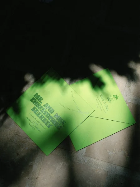 Wedding invitation suite with neon green wedding invitations and matching envelope, bold typography and return address on stone tile with leaf shadows