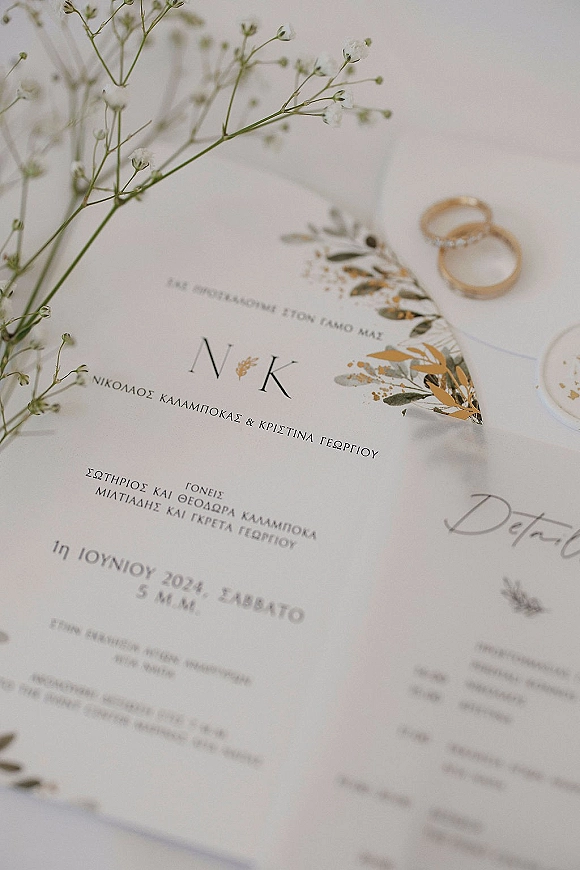 Wedding invitation suite with botanical wedding invitations, gold foil detail, and wedding rings on a soft neutral surface with wax seal