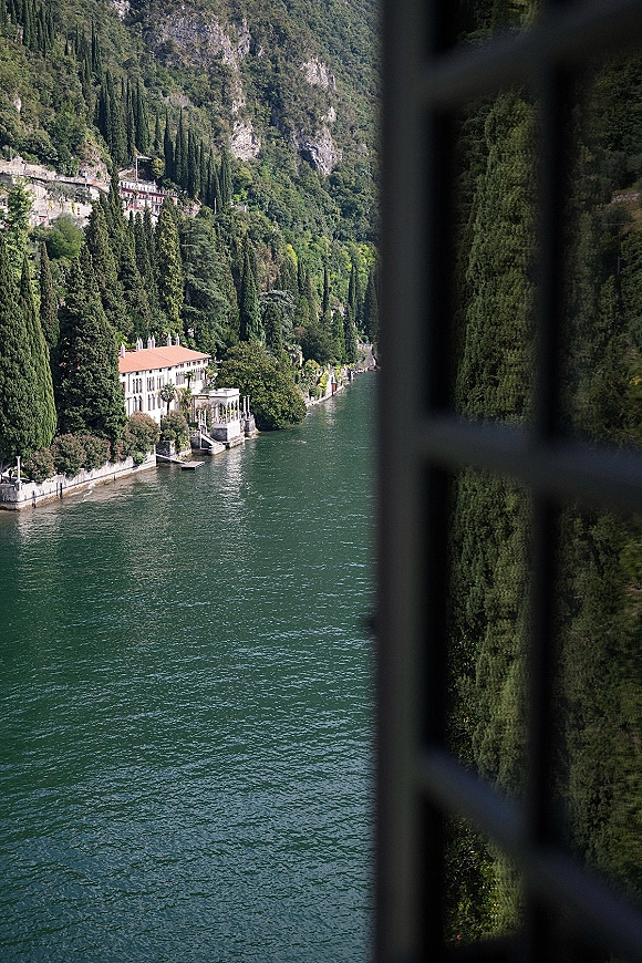 Lake wedding venue with a waterfront wedding venue villa, dock and terrace overlooking a calm lake with cypress trees and forested mountainside