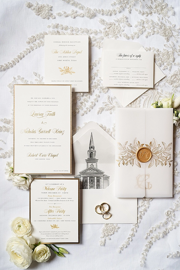 Invitation suite with wedding invitation suite cards in gold foil, botanical art, wax seal, rings and white roses on embroidered lace fabric