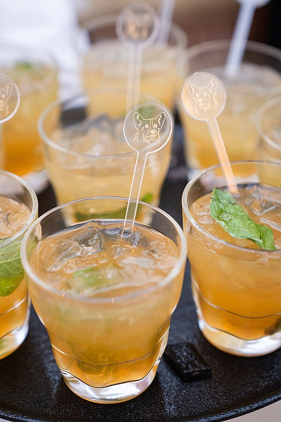 Wedding signature cocktails with mint garnish in rocks glasses on a black serving tray, finished with etched acrylic swizzle sticks