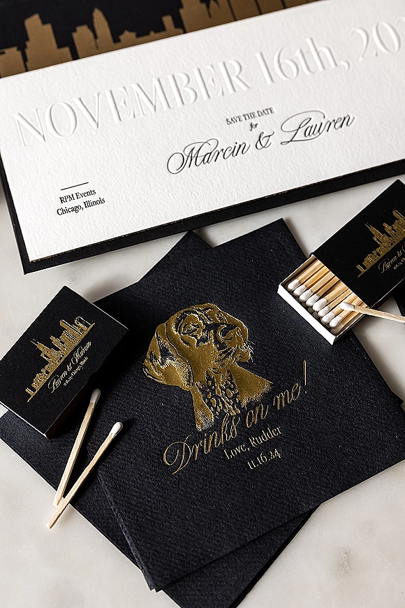 Wedding invitation suite with letterpress save the date, black envelopes, and gold foil details arranged on a white tabletop