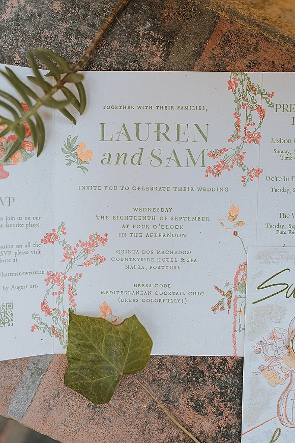 Wedding invitation suite with botanical wedding invitations, illustrated cards and a greenery sprig arranged on a textured stone surface