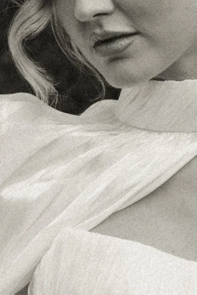 Wedding dress close-up featuring a high neck wedding dress with a soft neck scarf delicately draped around the neckline.