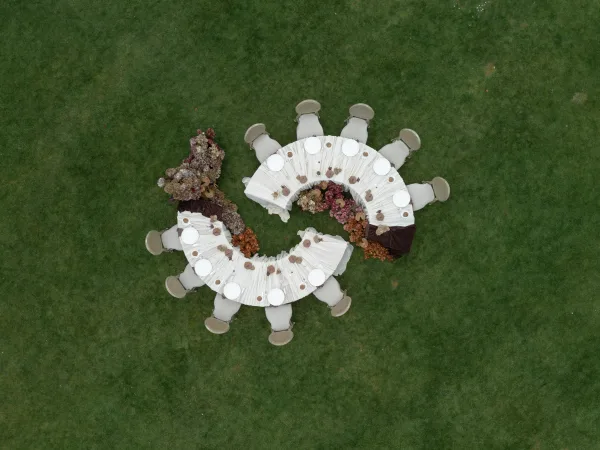 Serpentine reception table featuring outdoor reception decor, with airy florals winding along its curves.