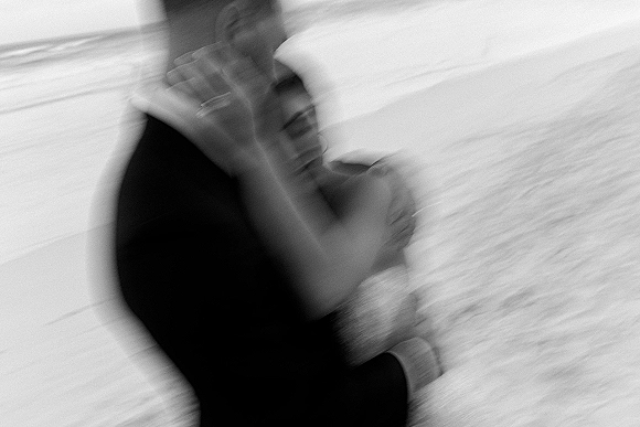 Wedding dance moment as bride and groom sway in close embrace on the dance floor, her strapless wedding dress beside his suit