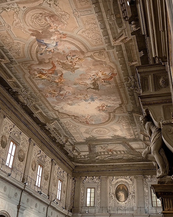 Ornate wedding venue historic wedding venue interior with a fresco ceiling, gilded moldings, chandeliers, and tall windows in a grand hall