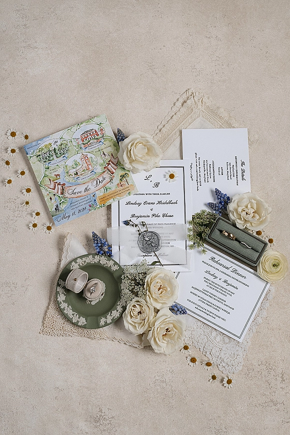 Invitation suite wedding invitation flat lay with wax seal, lace, velvet ring box and rings, styled with white roses on linen surface