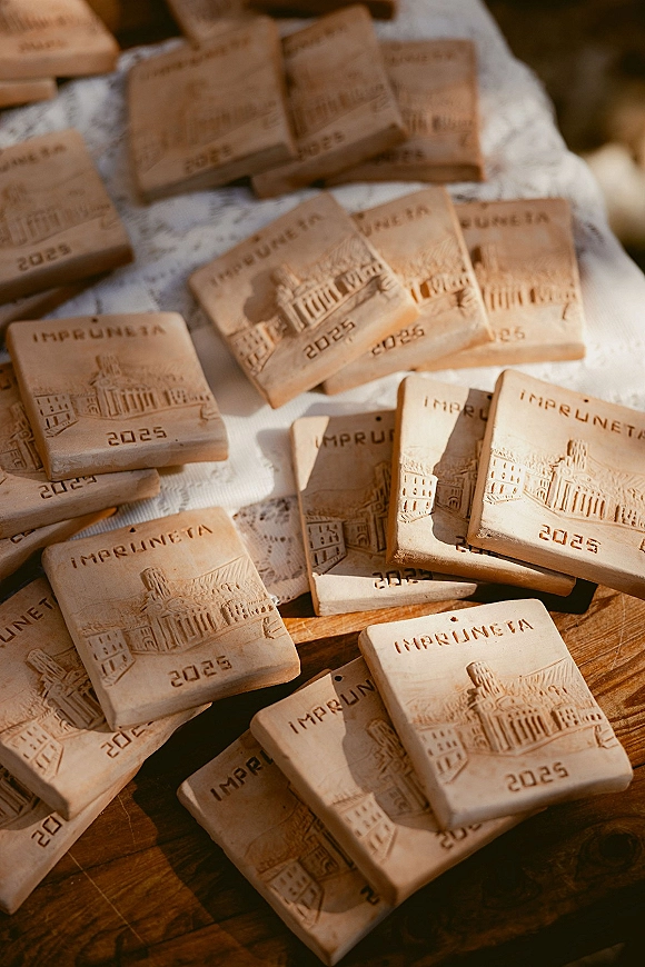 Wedding favors featuring personalized wedding favors embossed cookies with imprinted text on a lace tablecloth atop a wooden table in warm sunlight