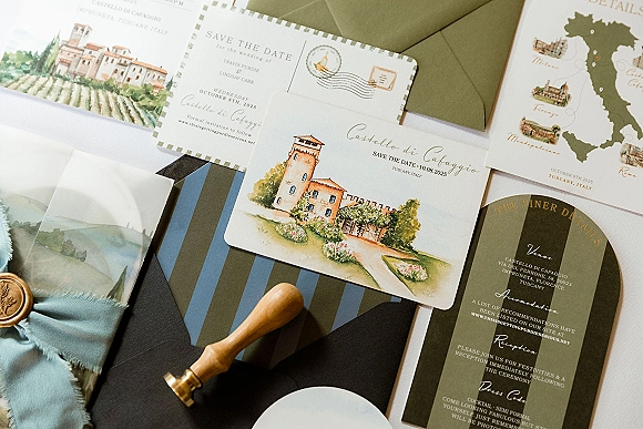 Wedding invitation suite with save the date card, watercolor venue illustration, map card, and wax-sealed envelope on white fabric backdrop