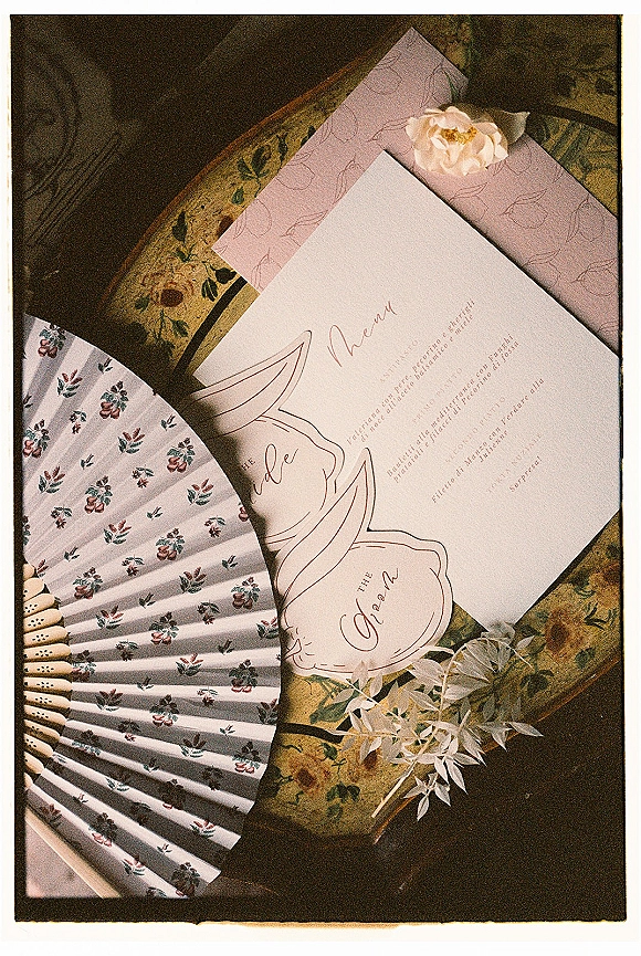 Wedding invitation suite with wedding menu card, place card and envelopes, with blush flower and greenery on a vintage floral tabletop