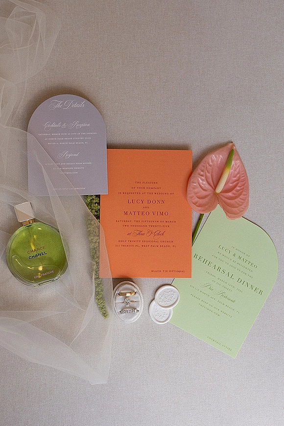 Invitation suite wedding invitation flat lay with arched cards, rings, wax seal, and pink anthurium on a linen surface