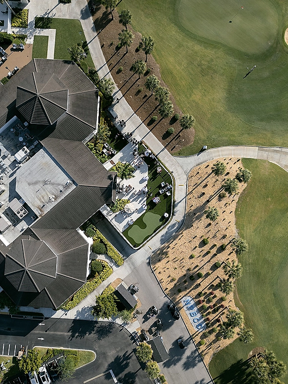 Outdoor cocktail hour wedding cocktail hour setup with standing cocktail tables in white linens on a country club patio by palm trees