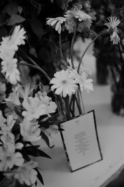 Floral arrangement of daisy wedding flowers arranged in glass bud vases, styled as a minimalist tabletop display for modern wedding decor.