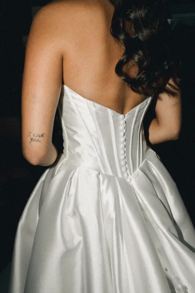 Wedding dress back of a button back wedding dress, spotlighting neat covered buttons cascading along the center seam