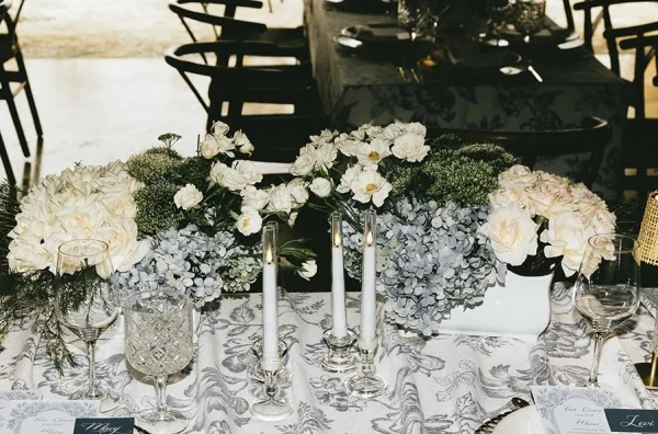 Reception tablescape on a blue and white wedding table, anchored by a hydrangea centerpiece at the center of the table.