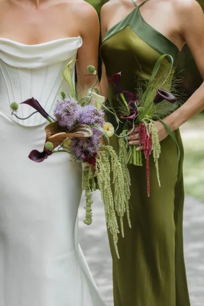 Wedding bouquet styled as a graceful calla lily bouquet, displayed along a garden pathway with surrounding trees.