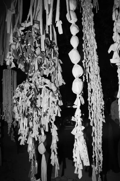 Wedding hanging decor with hanging ribbon installation of fabric streamers and garlands suspended from the ceiling in a dark reception space