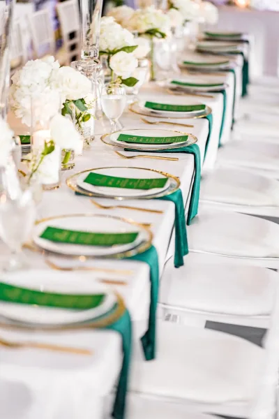 Reception tablescape with long banquet table decor, highlighted by luxe gold flatware along a streamlined, modern layout.