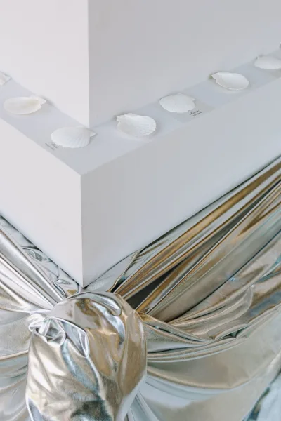 Wedding invitation suite with minimalist wedding invitations on a white tabletop, vellum cards in a box, seashells, and silver ribbon