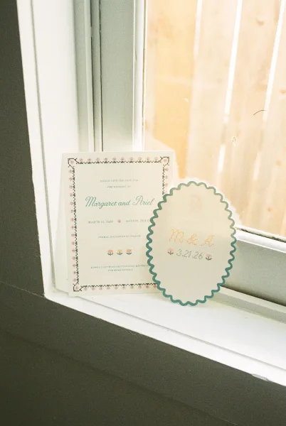 Save the date card from a wedding stationery suite, featuring a scalloped edge and a teal-and-cream palette, styled with understated elegance.