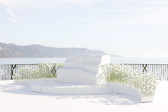 Wedding ceremony setup with modern wedding ceremony decor, featuring a white platform stage, clear chairs, and ocean-view terrace backdrop