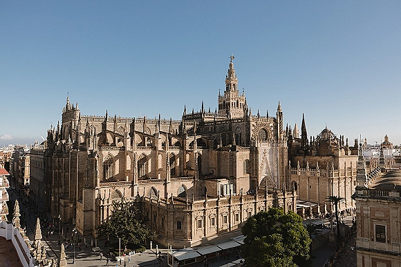 Cathedral exterior with gothic cathedral architecture, showing ornate stone towers and spires above city rooftops under a blue sky