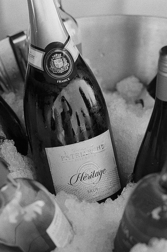 Champagne bottle chilled in ice in a metal bucket, wedding champagne label visible with additional bottles in the background