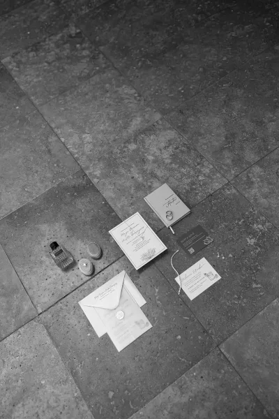 Wedding invitation suite featuring modern wedding invitations, accented by a wax seal and arranged neatly on a stone tile floor.