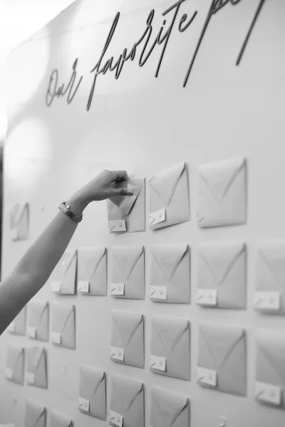 Escort card display arranged as an envelope seating chart, rows of white envelopes on a clean display board for guests to find their seats.