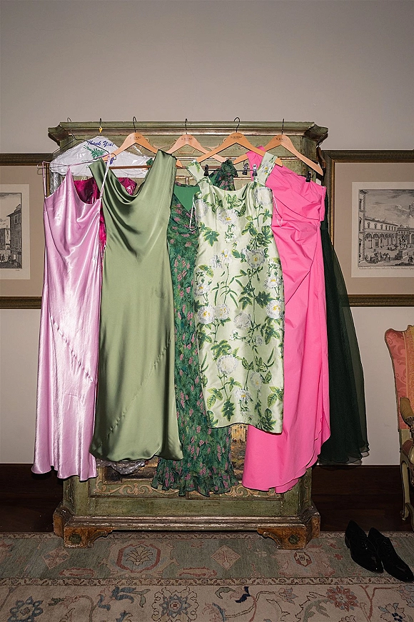 Bridesmaid dresses in mix and match bridesmaid dresses style hanging on a vintage armoire, with pink, green and floral options on hangers