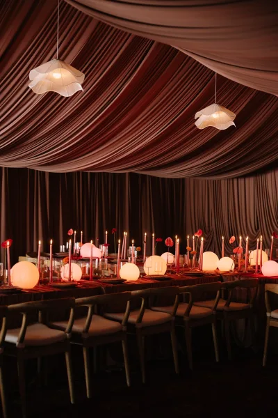 reception tablescape aglow as a candlelit reception table, featuring sculptural anthuriums beneath a softly draped fabric ceiling