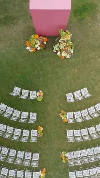 Ceremony setup with outdoor ceremony seating, highlighted by playful fruit decor lining the aisle path.