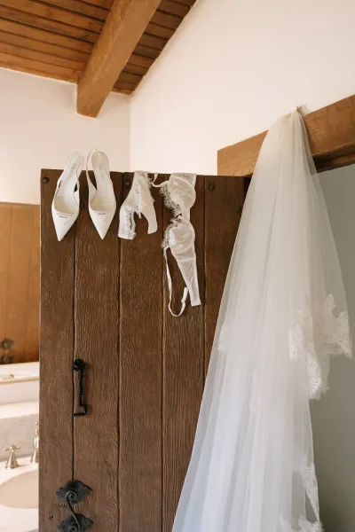 Bridal accessories featuring white wedding heels styled with delicate lace lingerie, arranged for wedding morning detail styling.