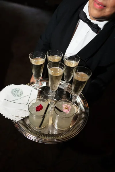 Cocktail hour drinks feature butler passed champagne on a silver tray, elegantly offered to wedding guests during the reception.