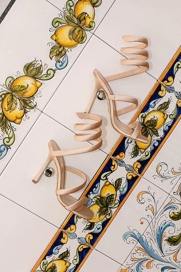 Bridal shoes in a wedding shoes flat lay, nude strappy high heel sandals on painted lemon motif ceramic tiles with blue-yellow border