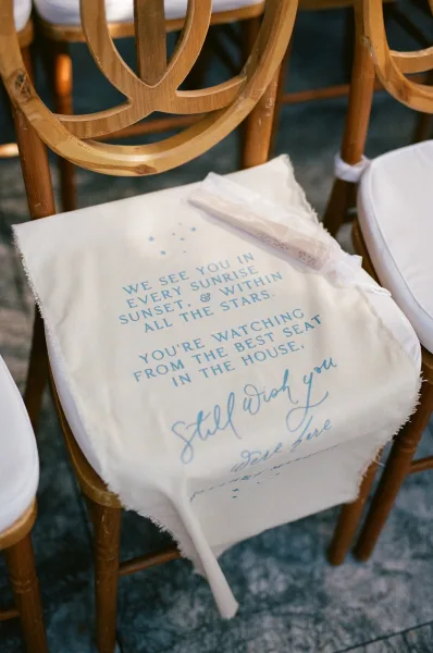 Memorial chair sign marking an empty chair tribute, a fabric banner tied to the chair back to honor a loved one with a simple, understated touch.