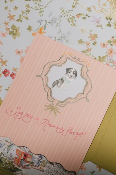 Save the date card with a dog illustration invitation, elegantly presented on floral patterned paper for a charming, playful feel.