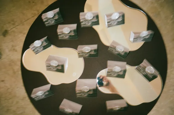 Escort card display featuring wax seal escort cards neatly arranged in concentric rows on a round table, ready for guest seating pickup.