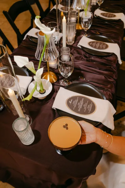 Reception tablescape on a modern black reception table with calla lilies, styled in a chic, moody palette for an elegant celebration.