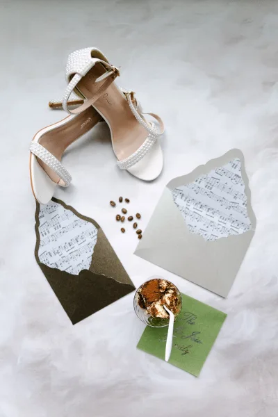 Bridal shoes, pearl wedding heels arranged beside wedding envelopes for a refined, romantic detail shot.
