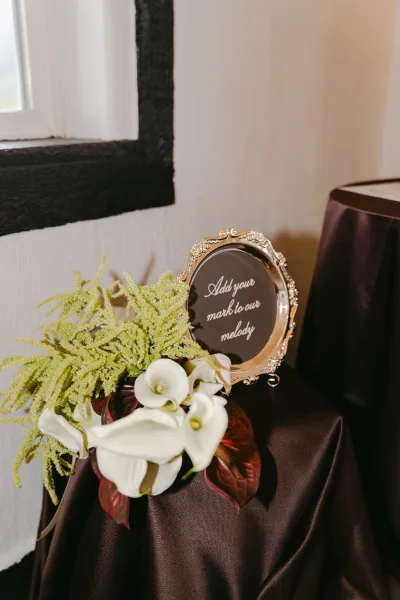 Wedding sign, a framed wedding sign adorned with calla lilies, elegantly displayed to welcome arriving guests.