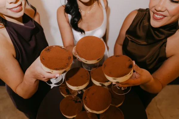 Wedding dessert tower of tiramisu dessert cups stacked in elegant coupe glasses, creamy layers creating a striking centerpiece.