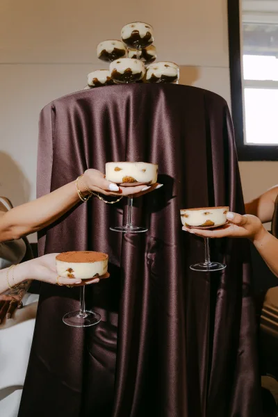 Wedding dessert display with tiramisu cups elegantly served in coupe glasses, showcasing creamy layered tiramisu for guests to enjoy.