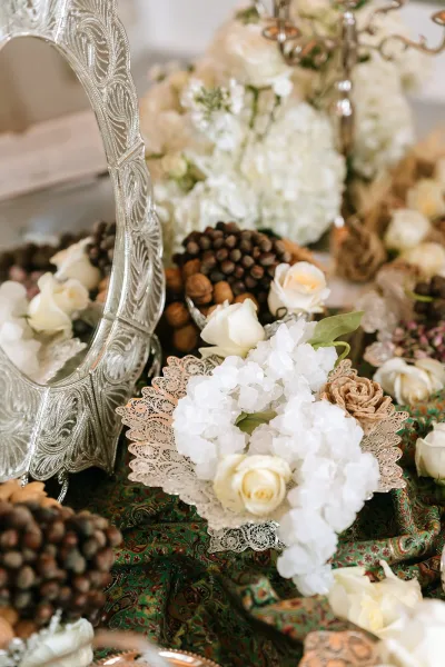 Sofreh aghd Persian wedding decor displayed as a symmetrical ceremony spread centered on a gleaming silver mirror