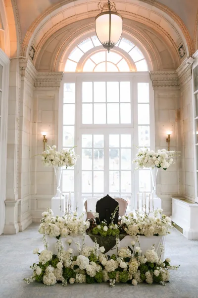 sweetheart table decor with head table flowers and candelabras, set by an arched window in a stone-walled ballroom