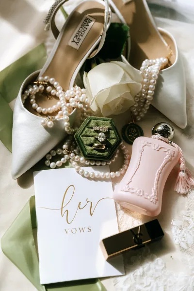Bridal details styled in a wedding flat lay, highlighted by lustrous pearls on delicate lace fabric.